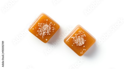 Salted caramel candy cubes drizzled with caramel sauce and sprinkled with sea salt on a clean white background viewed from above