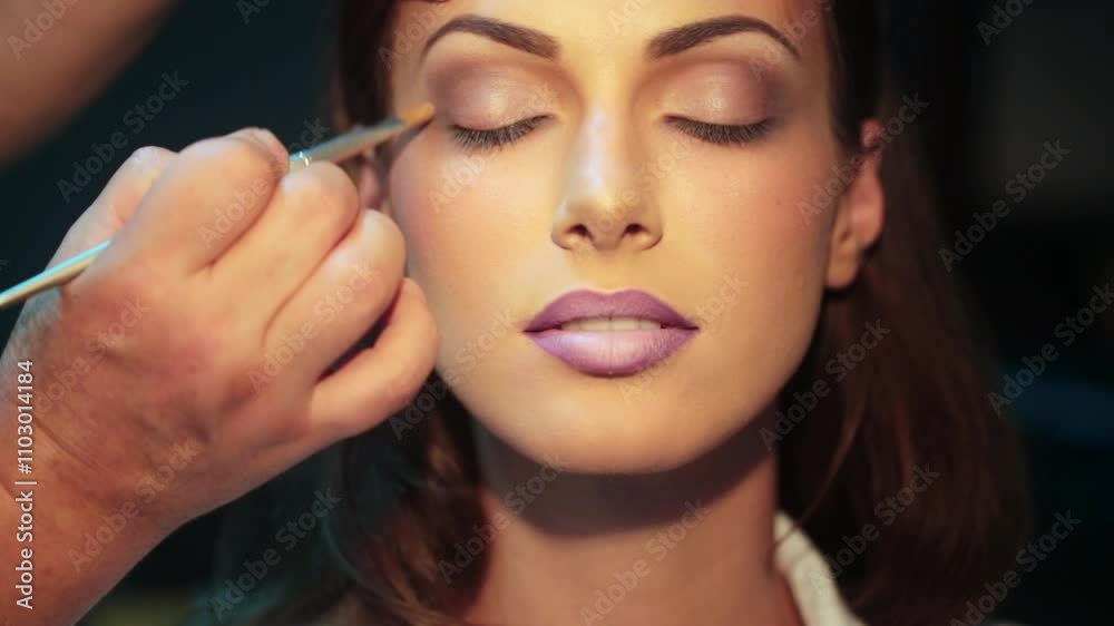 Makeup artist applying eyeshadow. Makeup beauty female eyes. Close-up eyeshadow make up face. Professional makeup artist with makeup model. Beautiful young woman with fashion eyeshadow.