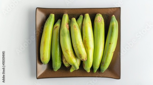 Ripe green pitangas beautifully arranged on a dark square plate with a clean white background for a fresh and vibrant presentation. photo