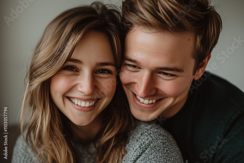 A joyful and affectionate couple in their 30s are pictured in a warm embrace.