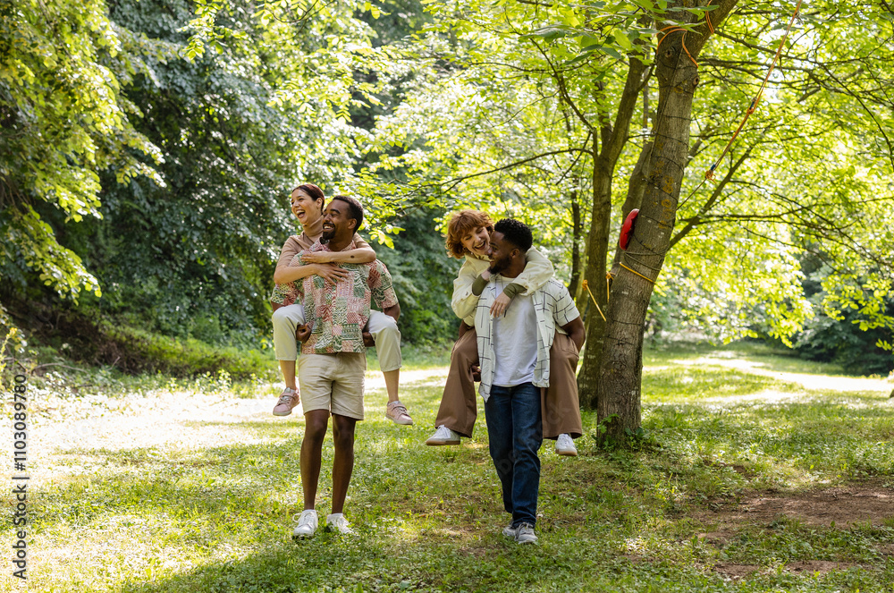 Two happy multiracial couples piggybacking in a park Two happy multiracial couples piggybacking in a park