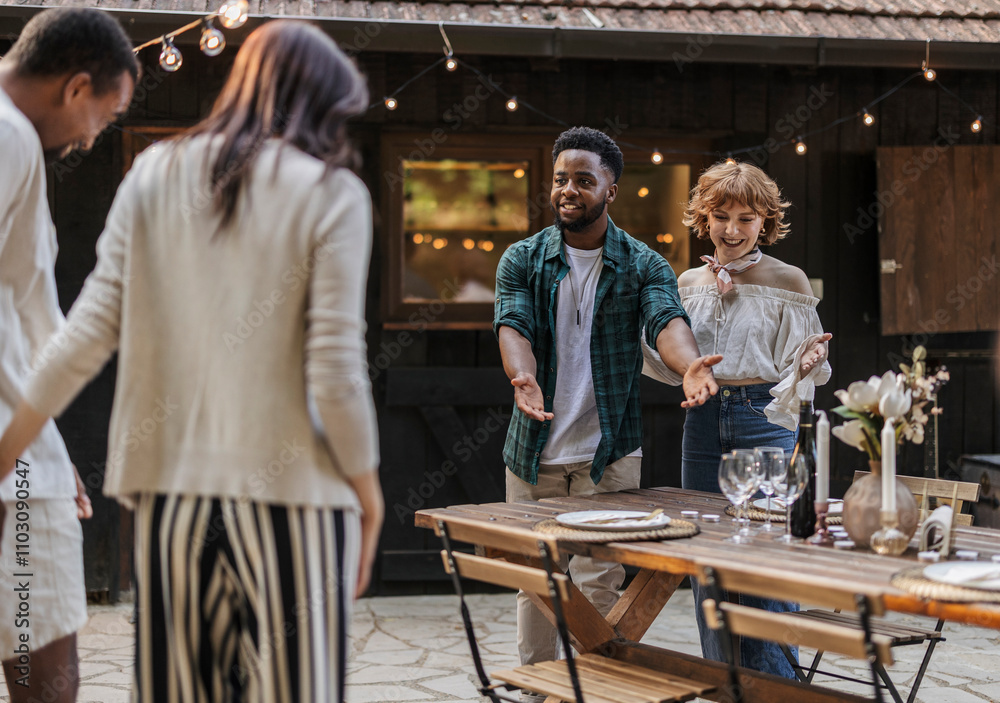 Friends welcoming guests to outdoor dinner party, Friends welcoming guests to outdoor dinner party,