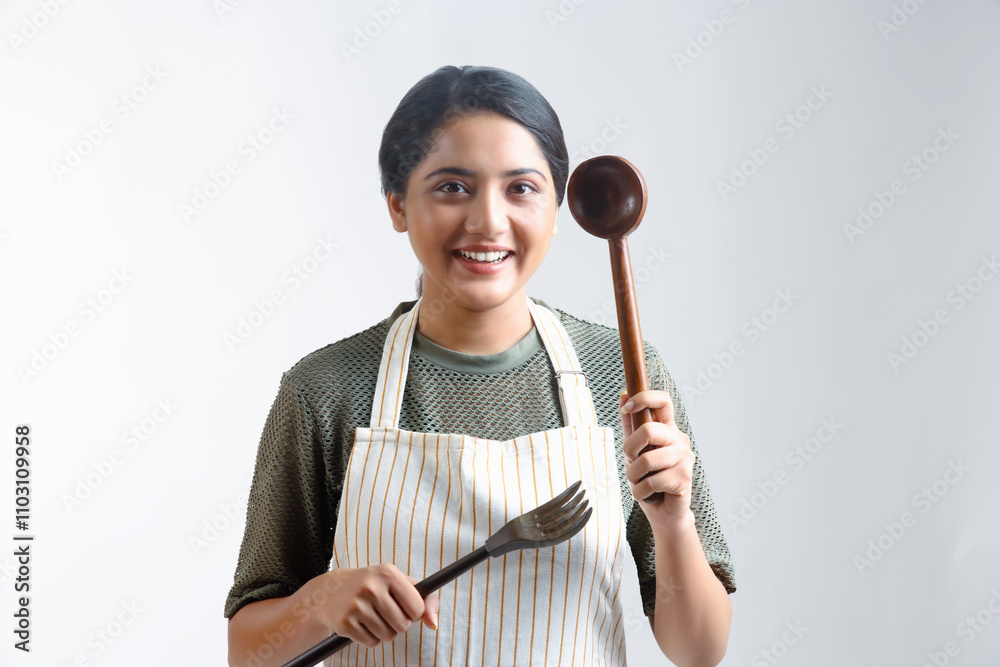 indian Young woman enjoy cooking healthy food in the kitchen at home. holding cooking ware and smiling. indian Young woman enjoy cooking healthy food in the kitchen at home. holding cooking ware and smiling.