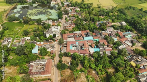 Aerial view of a serene village landscape, Picturesque rural scenery with lush greenery, Drone shot of a vibrant Indian village, Peaceful village with fields and a lake Stock Video.
 photo