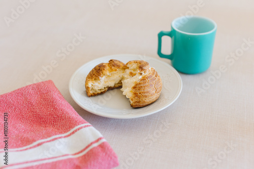 choux cream or cream puff or French profiteroles with fresh cream set on cafe table with antique colored cup photo