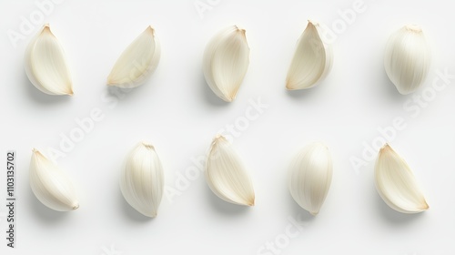 Whole garlic cloves arranged in a row on a white background showcasing their texture and fresh appearance