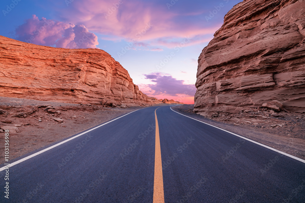 Asphalt road and Yardang landform mountain natural landscape at dusk in Xinjiang, China. Outdoor natural background. Asphalt road and Yardang landform mountain natural landscape at dusk in Xinjiang, China. Outdoor natural background.