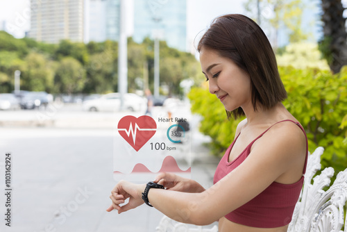 Women Point to smartwatch displaying heart rate application. Monitoring virtual display measure heart rate before after physical exercise. wristwatch checking heart beats and pulse.