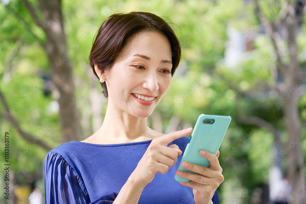 公園でスマホを操作する女性