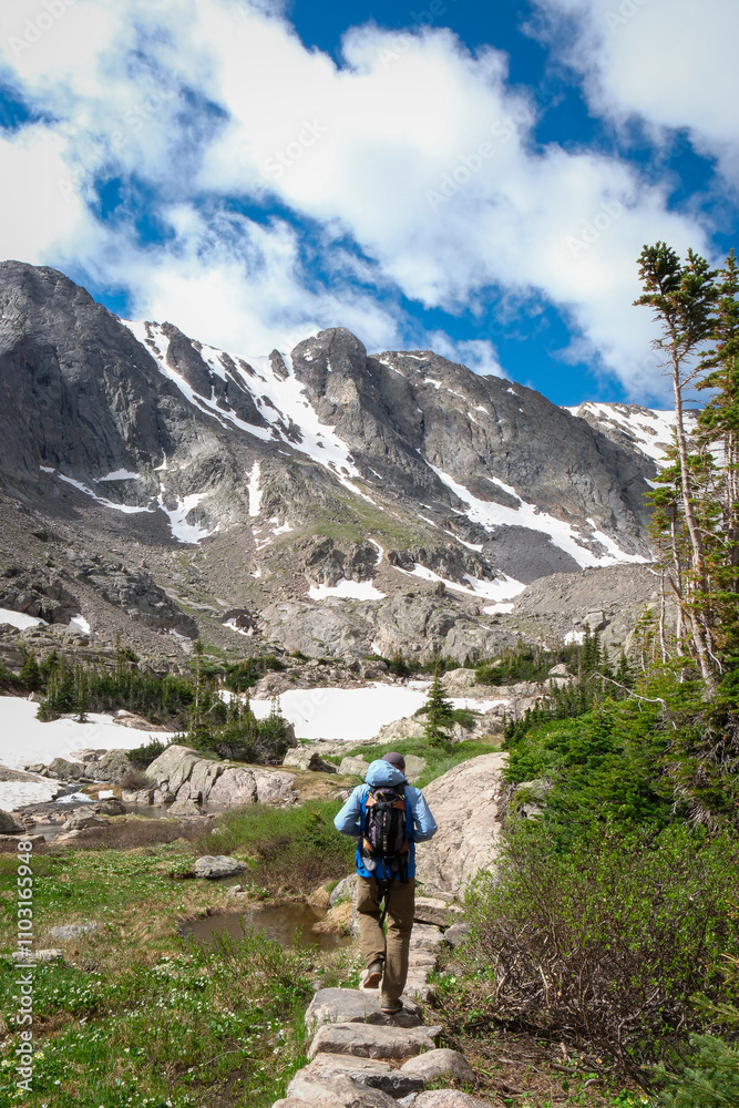 A man hikes along a stone path in the backcountry. A man hikes along a stone path in the backcountry.