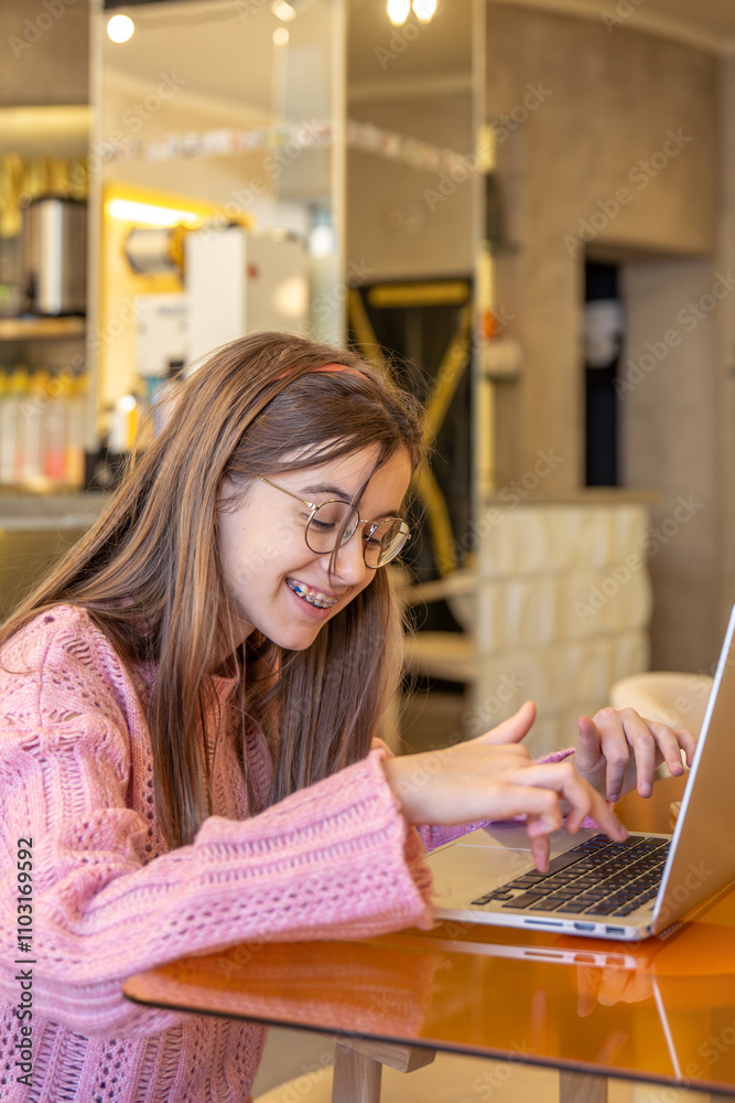 A happy teenage girl is working on a laptop. Distance education. A happy teenage girl is working on a laptop. Distance education.