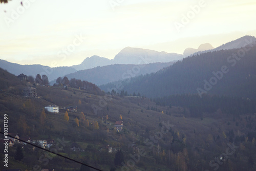 Twilight in Plav: houses on the outskirts of the city surrounded by forest and scenic mountains of Prokletije National Park. Life in the mountains of eastern Montenegro: evening landscape. photo