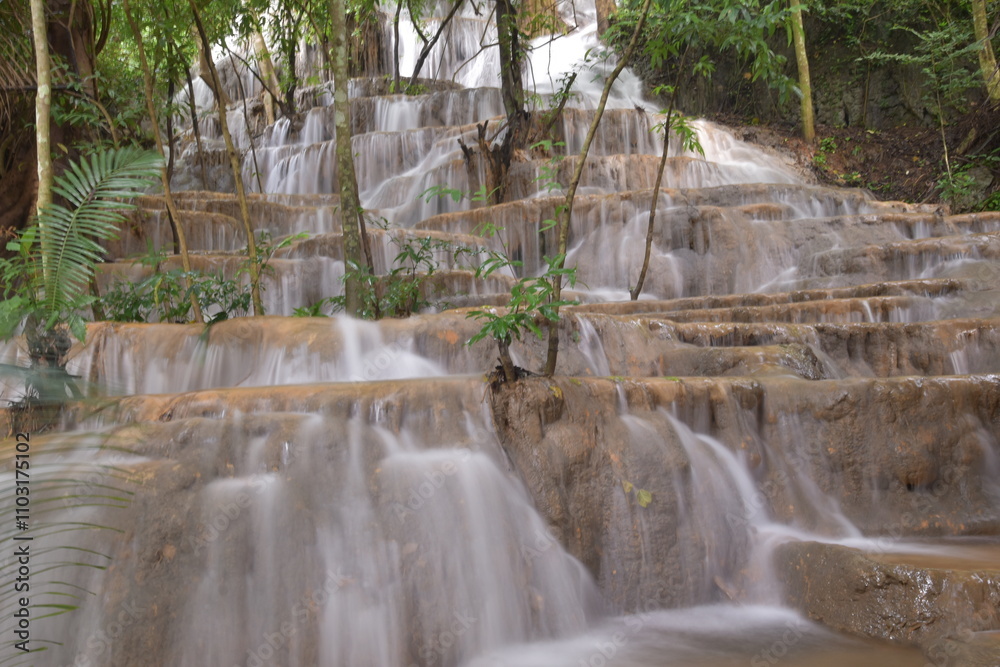 Obraz premium Travel to waterfalls during the rainy season, The tiers of the waterfall contrast beautifully with the sky, Nature itself is the best physician