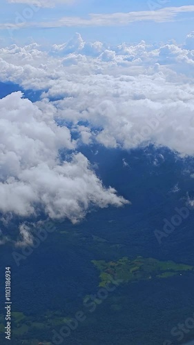 Aerial view of a vibrant blue sky with fluffy white clouds through an airplane window. Travel concept. freedom, adventure, wanderlust, relaxation
