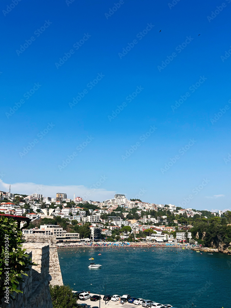 Obraz premium Idyllic coastal town with vibrant blue sky and serene bay. Ulcinj, Montenegro