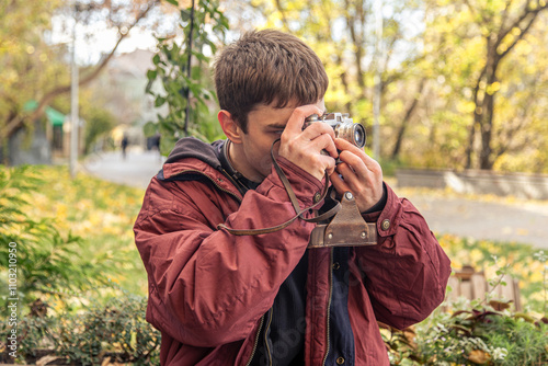 A young man takes pictures on a vintage camera. Film camera photography.