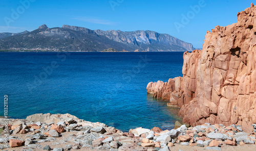 red  granite rock on the edge of a the  clear sea in Sardinia Italy - Rocce R...