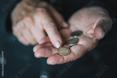 Defocused view to elderly woman counts metal coins, wrinkled female hands close up. Concept of poverty, pension payments, retiree with money. poverty of pensioners. old women's hands count coins. photo