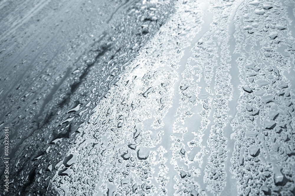Obraz premium rain water drops on a bonnet of a black car during rainy day