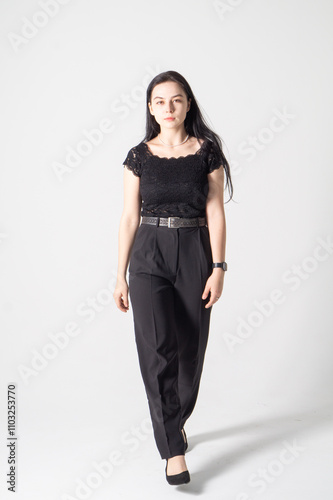 Cute young brunette girl standing on a white background. Copy space