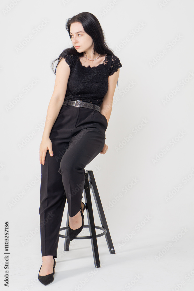 Cute young brunette girl sitting on a white background. Copy space Cute young brunette girl sitting on a white background. Copy space