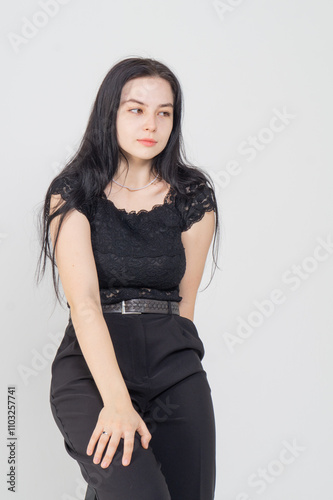 Cute young brunette girl sitting on a white background. Copy space