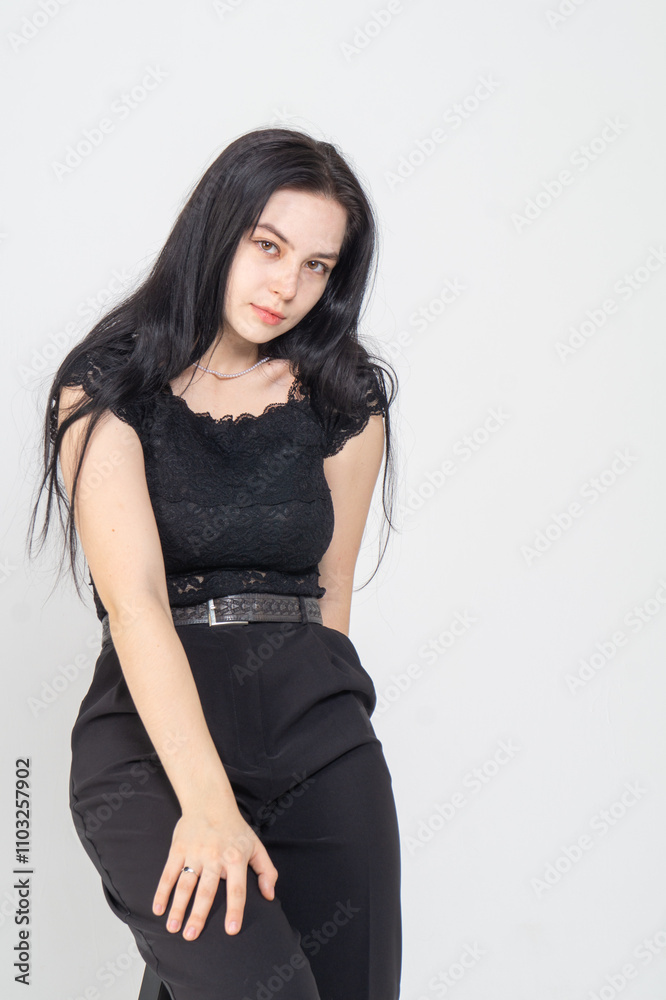 Cute young brunette girl sitting on a white background. Copy space Cute young brunette girl sitting on a white background. Copy space