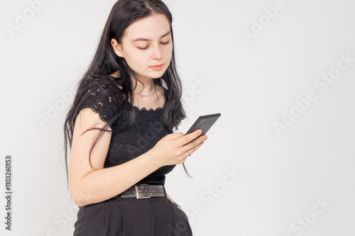 Cute young brunette girl communicating with cellphone on a white background