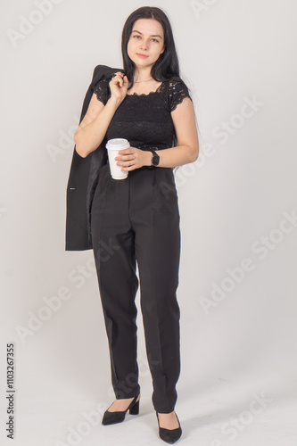 Cute young brunette with a coffee cup on a white background. Copy space