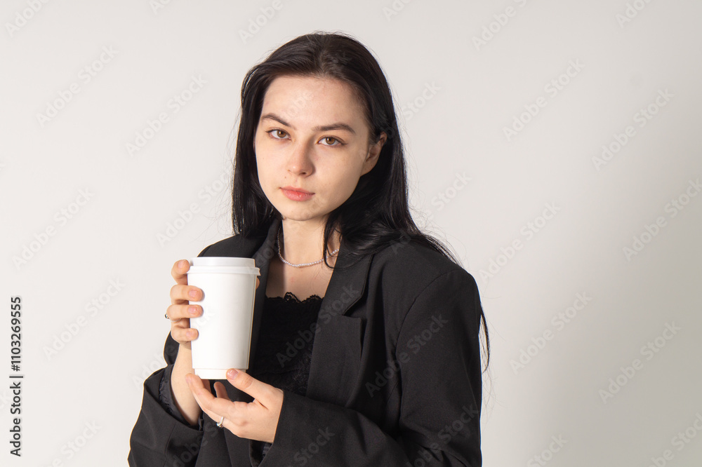 Cute young brunette with a coffee cup on a white background. Copy space Cute young brunette with a coffee cup on a white background. Copy space