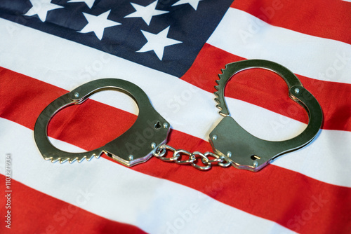 the concept of crime in the United States of America. police handcuffs on the usa flag, close-up