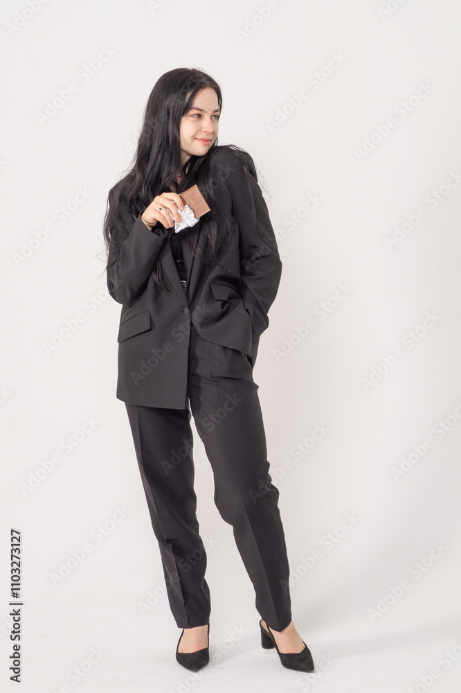 Cute young brunette with a chocolate bar on a white background. Copy space Cute young brunette with a chocolate bar on a white background. Copy space