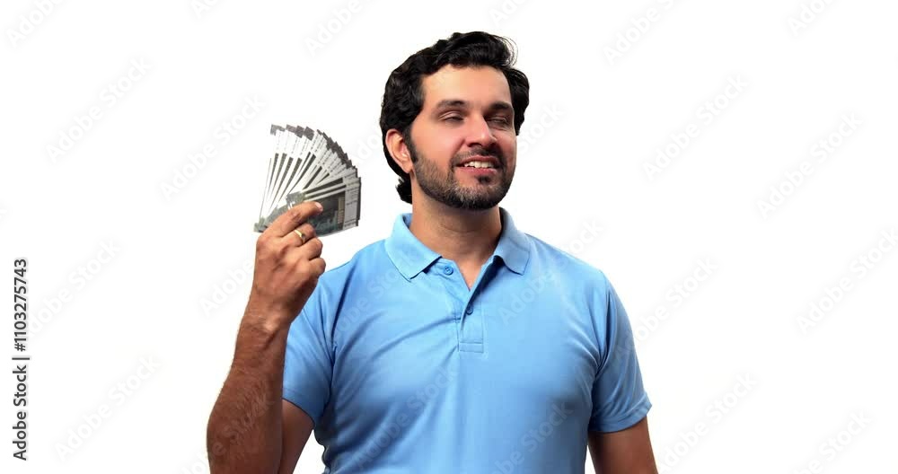 Indian bearded young man using a money fan made of paper currency notes to enjoy air, expressing joy and excitement of winning a lottery, savings, or receiving a bonus, standing isolated against white Indian bearded young man using a money fan made of paper currency notes to enjoy air, expressing joy and excitement of winning a lottery, savings, or receiving a bonus, standing isolated against white