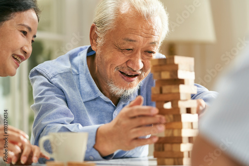 happy asian old people playing with building blocks at home