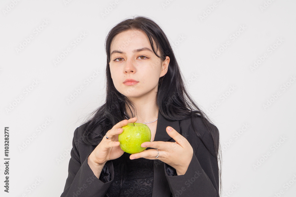 Young cute brunette girl with a red apple on a white background. Copy space Young cute brunette girl with a red apple on a white background. Copy space
