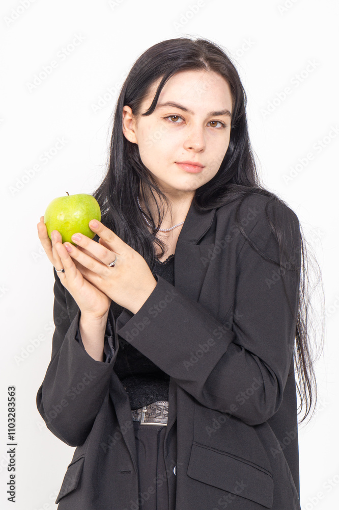 Young cute brunette girl with a red apple on a white background. Copy space Young cute brunette girl with a red apple on a white background. Copy space