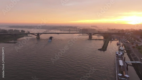 Aerial view of serene sunrise over the Waalbrug bridge and River Waal with beautiful cityscape and reflection, Nijmegen, The Netherlands. photo