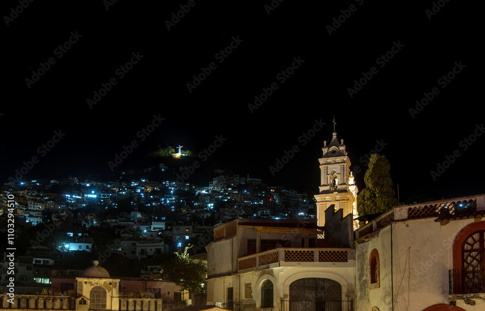 Nighttime view of Taxco de Alarcon with illuminated hillside and historic architecture Nighttime view of Taxco de Alarcon with illuminated hillside and historic architecture