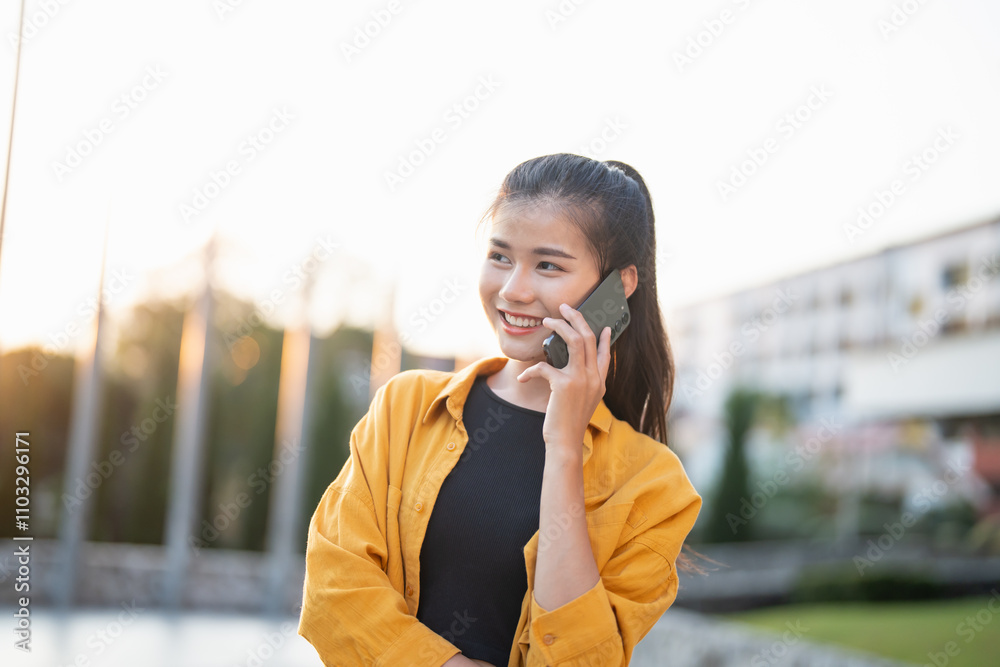 Smiling young Asian woman using smartphone in urban city checking apps mobile outdoors Smiling young Asian woman using smartphone in urban city checking apps mobile outdoors