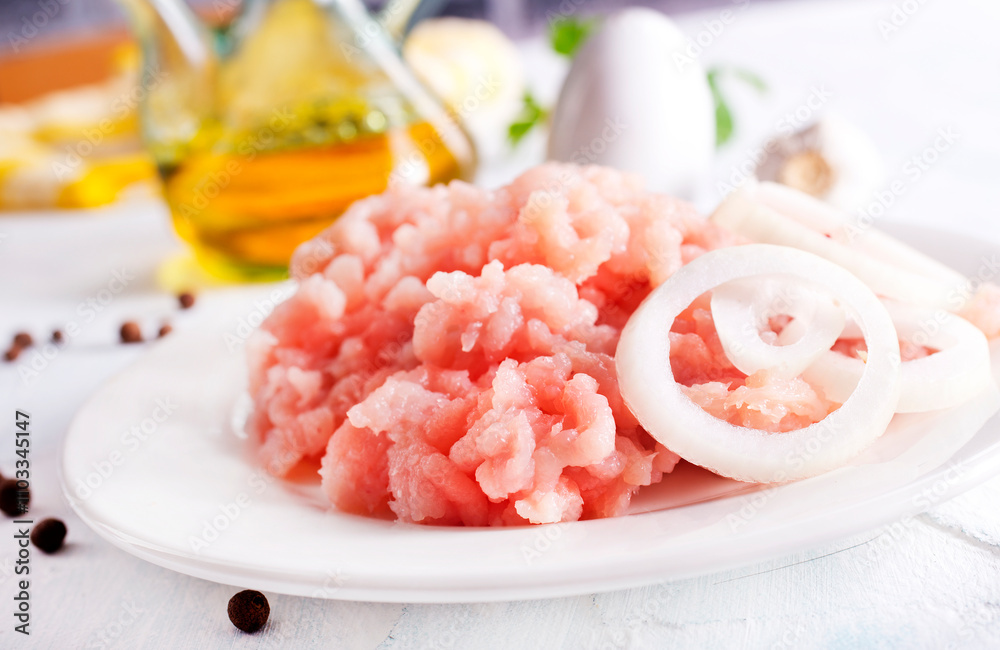 Minced Meat with herbs and onion on wooden table Minced Meat with herbs and onion on wooden table