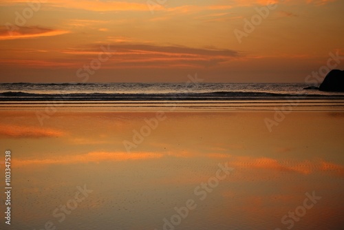 
Beautiful golden seascape with reflections of golden sunlight, ocean waves, sunrise on the coast near the beach in summer day.