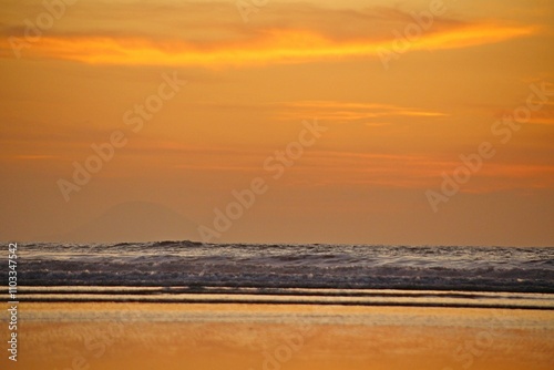 
Seascape with reflections of golden sunlight, ocean waves, sunrise on the coast near the beach in summer day.
