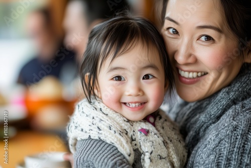 A cheerful mother and her young child share a joyful moment during a family gathering.