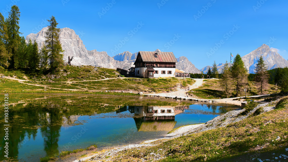 Fototapeta premium Mountain hut and lake scene