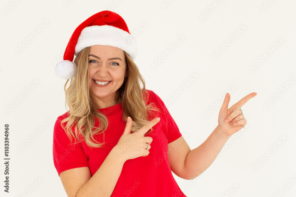 Smiling young Santa woman in Christmas hat pointing index fingers aside on mock up copy space isolated on white background, studio portrait. Happy New Year celebration concept Smiling young Santa woman in Christmas hat pointing index fingers aside on mock up copy space isolated on white background, studio portrait. Happy New Year celebration concept
