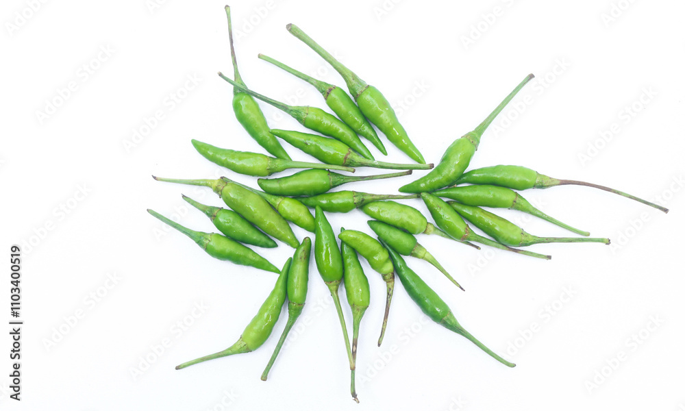 Fototapeta premium Collection of small green bird's eye chilies on a white plate isolated on a white background. Small hot bird's eye chilies for making chili sauce