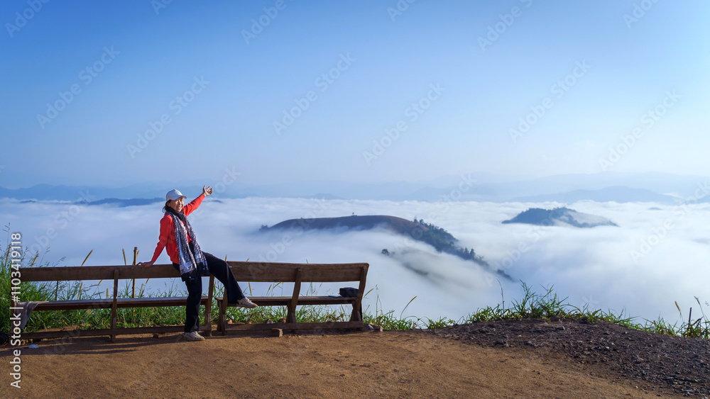 Asian woman is relaxed with the beautiful natural scenery a sea of mist of the Po ku de viewpoint in the morning. Tourism was natural in Mae Chaem, Chiang Mai, Thailand. Travel natural recreation. Asian woman is relaxed with the beautiful natural scenery a sea of mist of the Po ku de viewpoint in the morning. Tourism was natural in Mae Chaem, Chiang Mai, Thailand. Travel natural recreation.