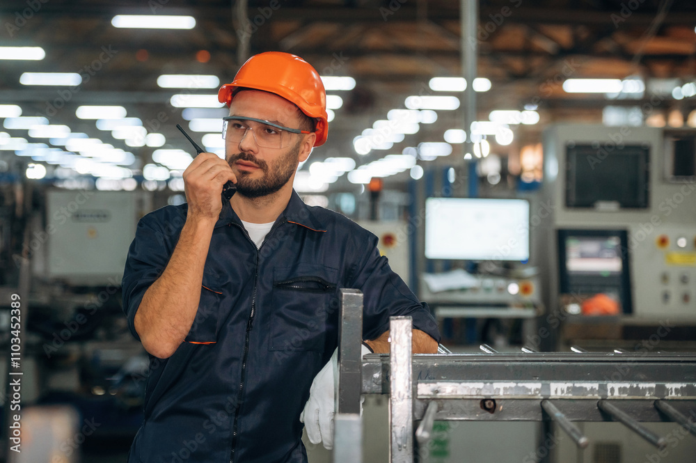 Giving instructions, using radio, walkie talkie. Man is working in the modern factory Giving instructions, using radio, walkie talkie. Man is working in the modern factory