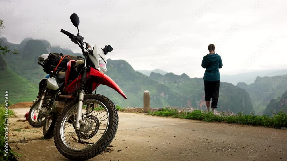 Female tourist near motorbike enjoy view at mountain lookout, Ha Giang Loop Female tourist near motorbike enjoy view at mountain lookout, Ha Giang Loop