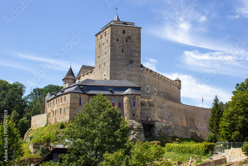 Fairytale, medieval, stone castle Kost with windows and arches. Built on a rock with green trees in the Czech Republic